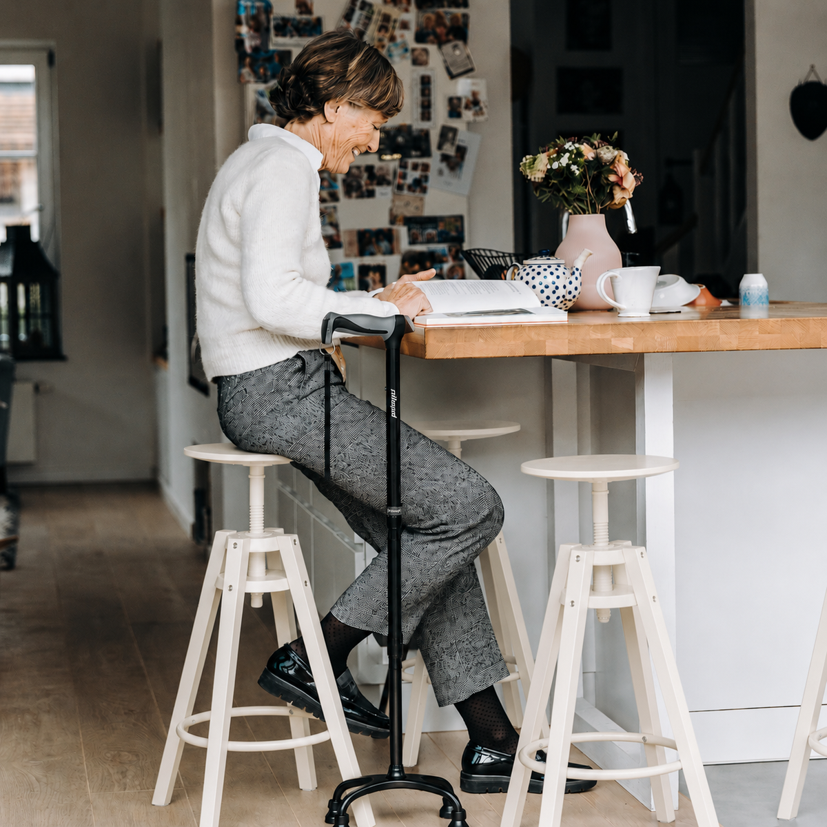 Woman seated at a kitchen counter with a self-standing cane